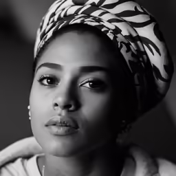 a black and white photograph of a woman wearing a turban