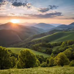 the sun sets on a mountain valley in the distance