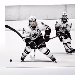 a black and white photo of two ice hockey players