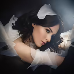 a woman with dark hair wearing a white dress
