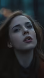 a woman with long brown hair is staring to her left