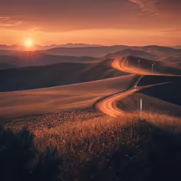 road winding in direction with a sunset and mountains in background