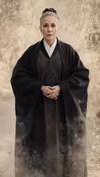 a woman in a long dress and a black cloak