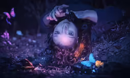 a beautiful young woman laying in the dark with a butterfly