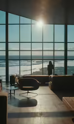 a woman is standing in front of a window overlooking the ocean
