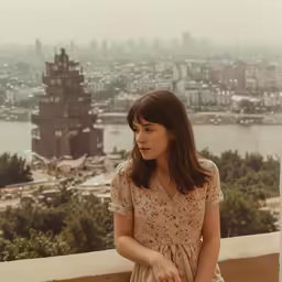 a woman holding an open umbrella looking over a city