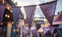 purple fabric drying on a clothes line in a busy street