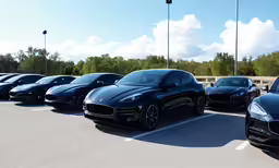 four black cars sit parked together in a row