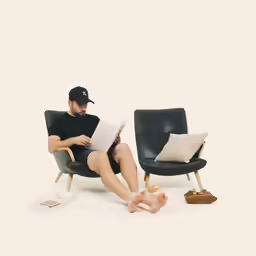 a man sitting in a chair reading a book