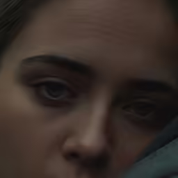 the evil woman looks towards the camera while covering her face