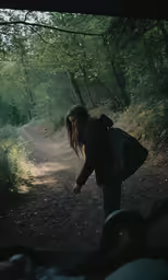 a woman with a back pack walks through a trail