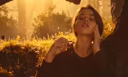 woman standing in sunlight holding her hand to her ear