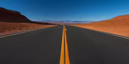 an empty street in the middle of a desert with mountains