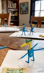 a couple of drawings are on a wooden table