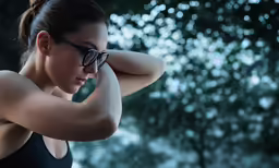 young women showing arm muscles wearing sunglasses and black shirt