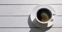 a cup of coffee with some green liquid in it