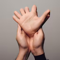 two hands reaching up to the sky, each holding something
