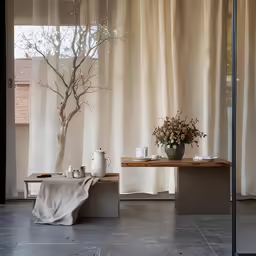 an empty vase sits near two tables with some white containers