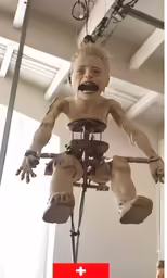 a dummy with many arms and legs hanging from a beam