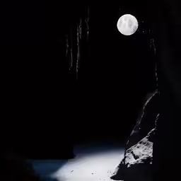 the moon is shown over a snowy pathway