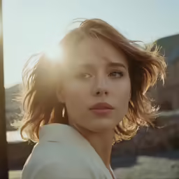 a woman with wavy hair and blue eyes in a white jacket