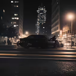 a large car driving down a street at night