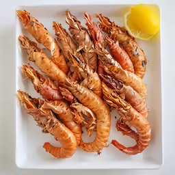 an arrangement of grilled seafood is displayed on a plate
