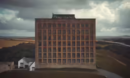 a very tall building sitting on top of a lush green hillside