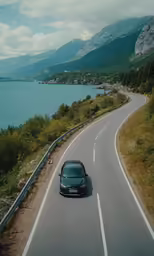 a blue car is driving down the highway next to water