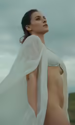 a very naked woman posing in the sun on a beach