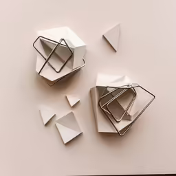 two paper holders are shown with square shaped objects