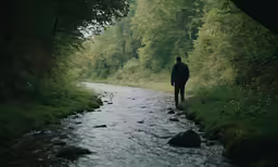 a man that is walking down a dirt road