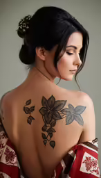 a woman with flower tattoos is looking down at her left shoulder