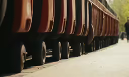 a row of cars with one red car attached