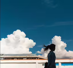 a woman standing in front of clouds with a guitar