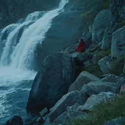 the girl is looking at the water fall