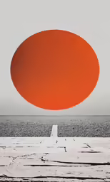 an orange oval over a beach with sand and water