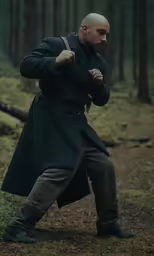 a man in an old fashioned green coat and boots