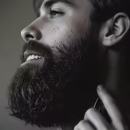 bearded man with curly hair and beard brushing his hair