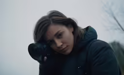 woman with black jacket holding camera to her face
