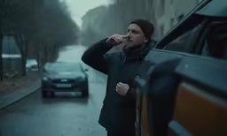 a man looking out of the window of his car