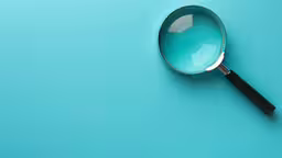 a close up of a magnifying glass on a turquoise surface,a magnifying glass on top of a blue surface