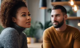 man and woman sitting together looking away from each other