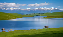 there is a lake in the foreground, and mountains in the background