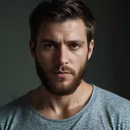 a close - up image of a man in a light shirt with beard