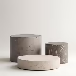 three cement containers sitting side by side on a white surface