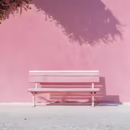a park bench in front of a pink wall