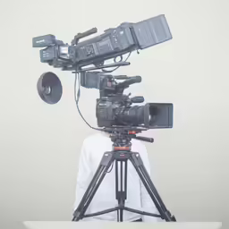 the young man is recording the movie on his tripod