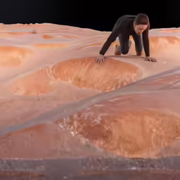 a man bending over on a rock formation