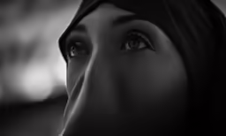 a woman wearing a head scarf looking off in the distance
